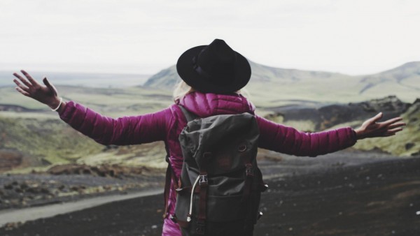 Finance's power for good Woman with arms out looking at landscape
