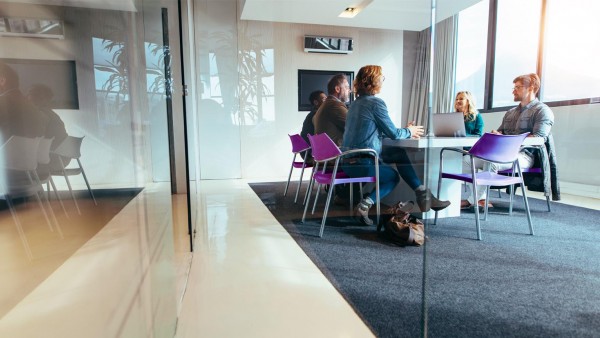 LIBOR transition: where are we now? Team of 5 collaborating in glass office