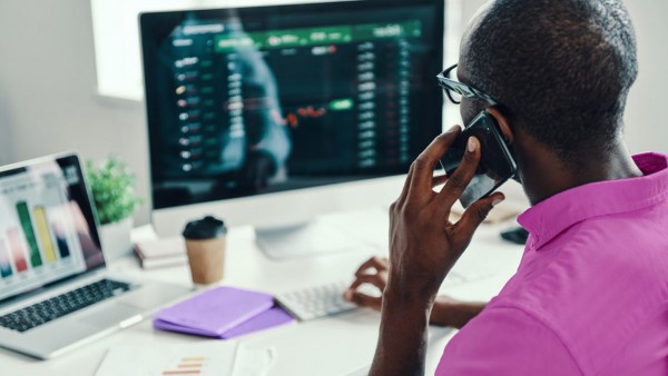Digital self-service in corporate lending: the treasury perspective Man on phone in front of computer