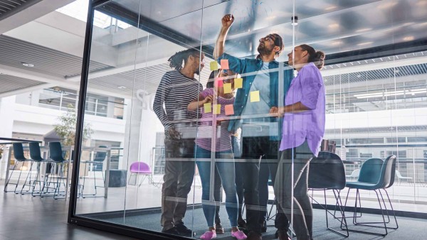 Interoperability: The key to instant payments Image of team collaborating in glass office