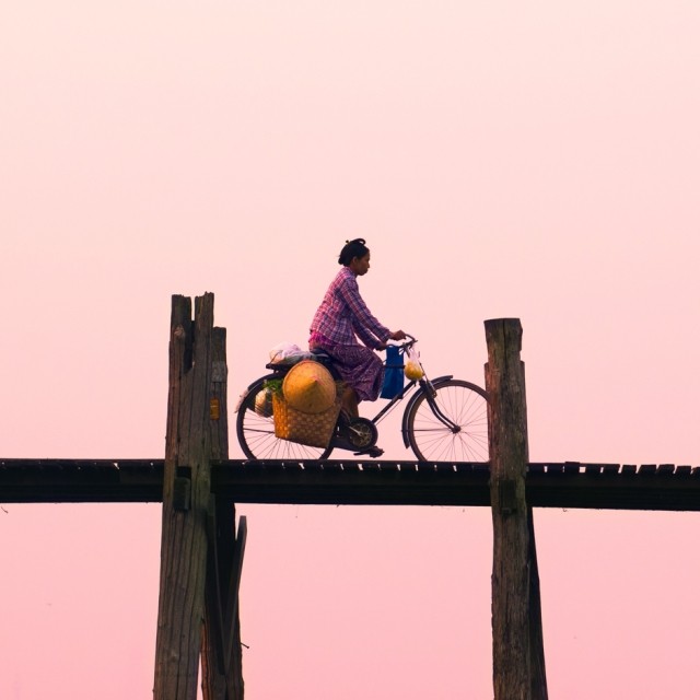 Woman riding bike on bridge