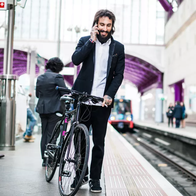 Man in subway with bike on phone