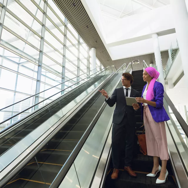 man and woman on escalator