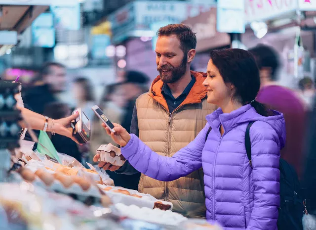 Image of man and woman using mobile payment in market