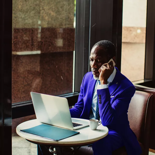 Image of man on phone and working inside an office