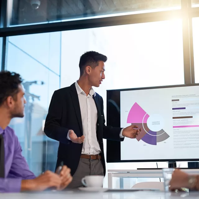 Image of a team meeting with a guy presenting chart
