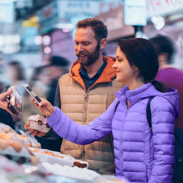Woman with man paying with phone