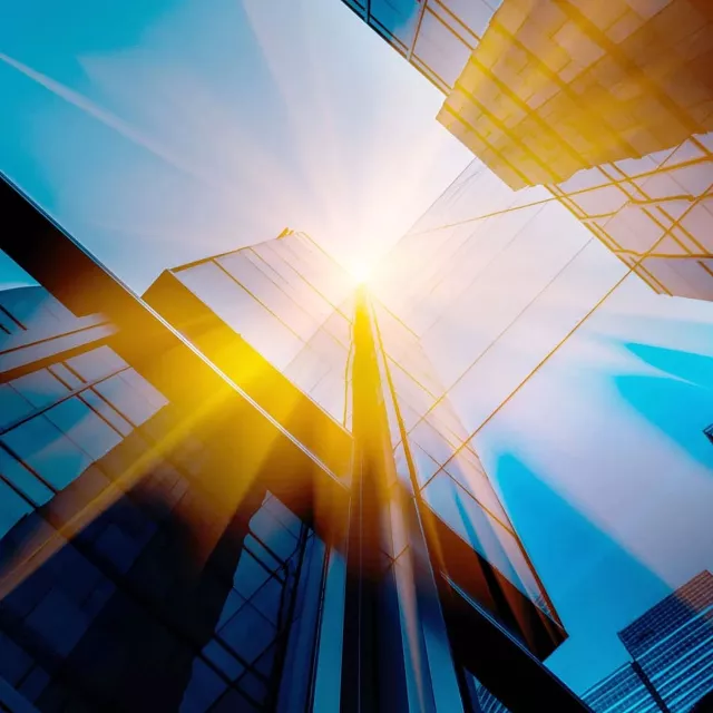 Worm's eye view of sun shining through buildings
