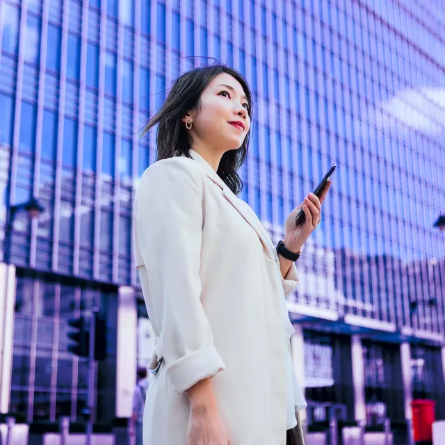 Image of woman holding phone outside
