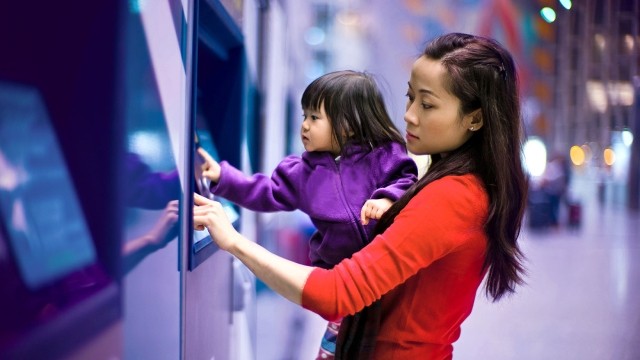 Image of mother and child using ATM