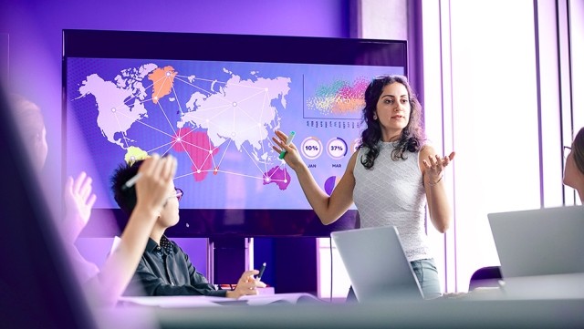 Image of woman presenting graphs and maps in meeting