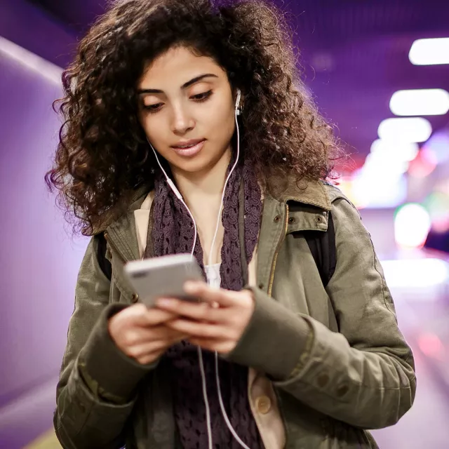Image of woman on phone with earphones on