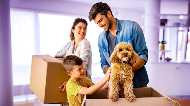 Image of a family unboxing with their dog
