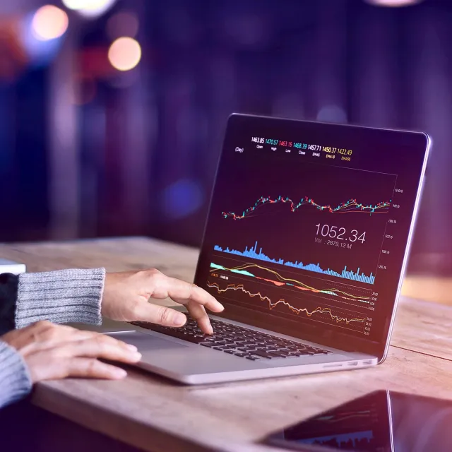 Image of laptop with graphs, and hands typing