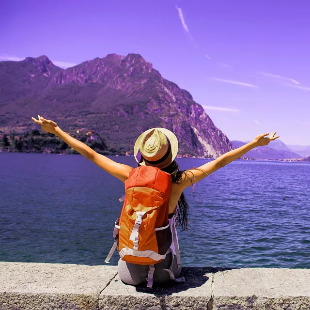 Image of woman looking at sea and mountain