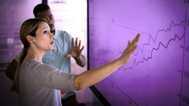 Image of man and woman discussing graphs