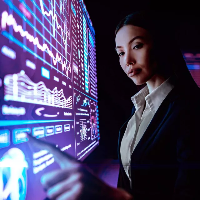Image of woman pointing at graph in monitor