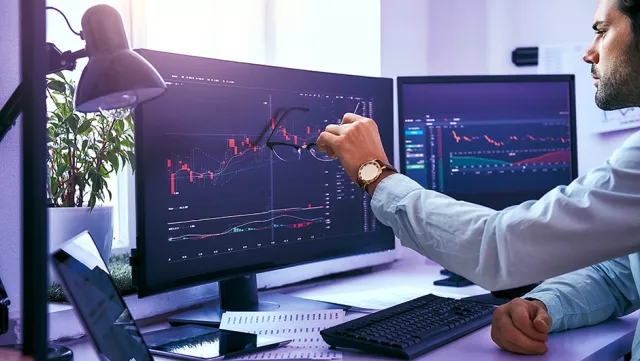Image of man checking graphs in monitors