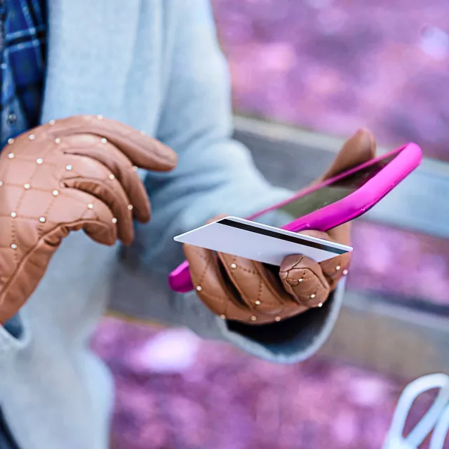 Image of hands holding a mobile phone and card