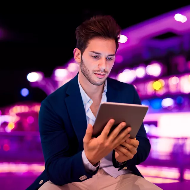 Image of man looking at tablet outdoors