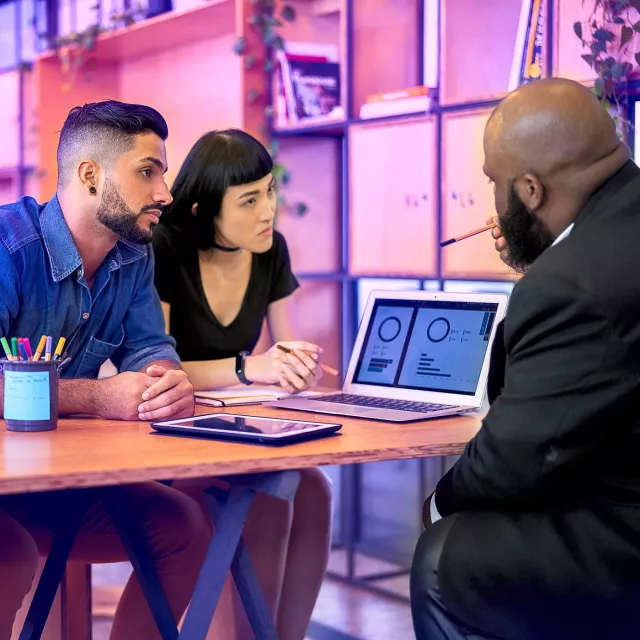 Image of man discussing graphs with a couple