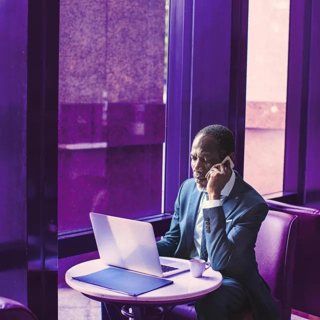 Image of man on a call in front of a laptop 