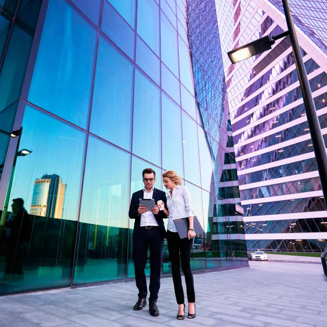 Business professionals outside a modern glass office building