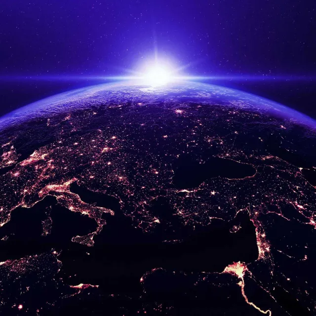Earth from space with illuminated cities and a purple sky