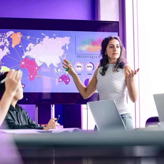 Business presentation with global data analytics, world map visualization, and collaborative team discussion.