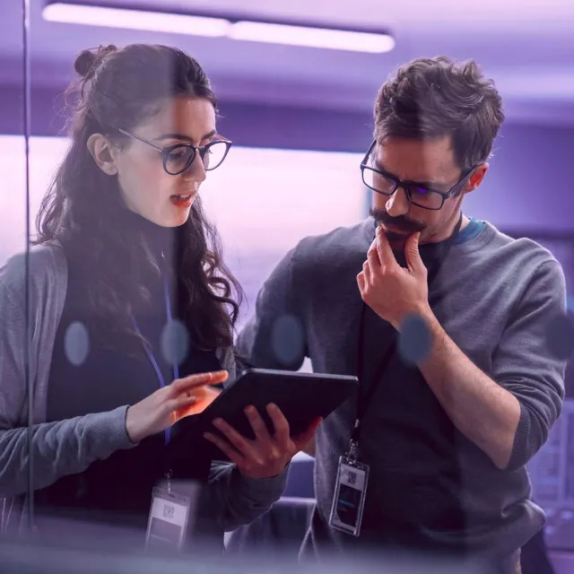 Image of officemates discussing while holding a tablet