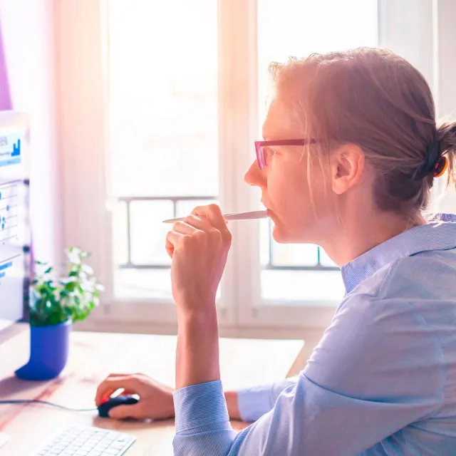 Image of woman thinking while in front of computer