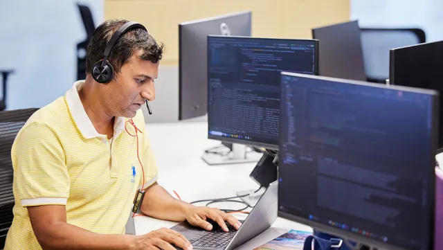 Image of man working on a laptop in an office