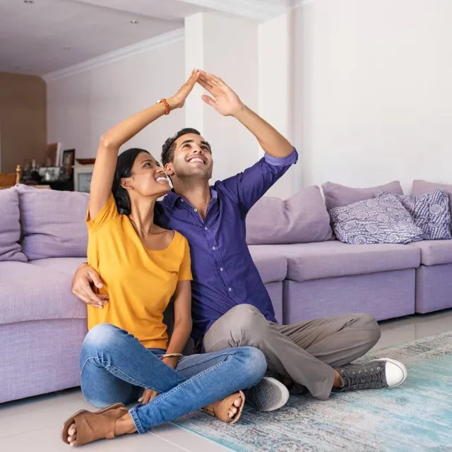 Image of couple sitting in the living room dreaming of a house