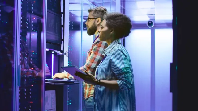 IT professionals managing data infrastructure in a high-tech server room.