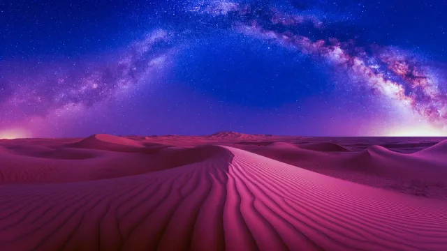 Vibrant pink desert dunes under a stunning Milky Way galaxy night sky with vivid stars and cosmic arc.