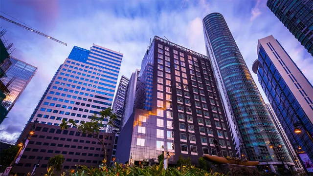 Modern skyscrapers in Manila’s business district under a vibrant evening sky.