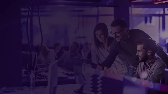 Young happy programmers cooperating while working on PC in the office.