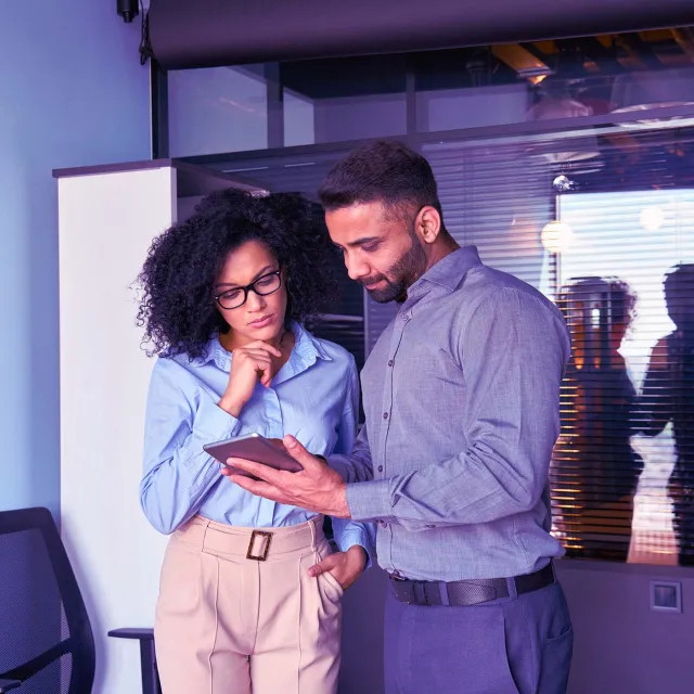 Team collaboration using digital tablet in modern office setting.