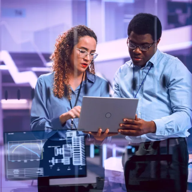 Multiethnic Robotics Engineer Talking to Project Manager, Discussing Robot Dog Concept in High Tech Research and Development Facility. Professional Industrial Scientists Working in the Background.