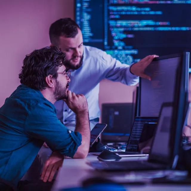 Programmers engrossed in deep collaboration, diligently working together to solve complex problems and develop innovative mobile applications with seamless functionality.