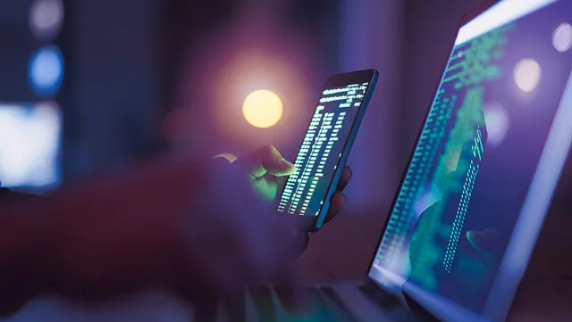 Secure coding and data analysis on smartphone and laptop screens.
