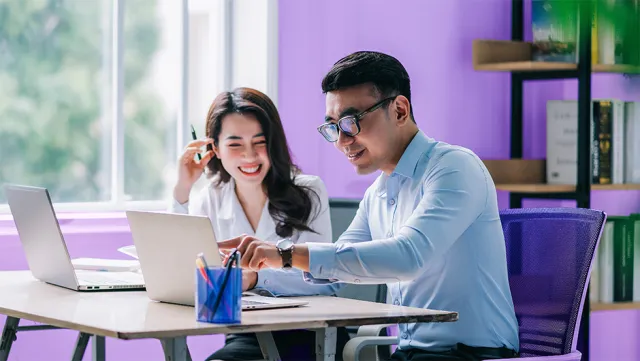 Colleagues collaborating on work projects in a bright modern office.