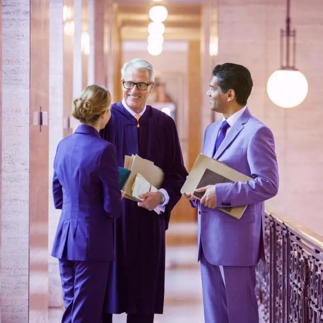 Image of three people discussing in a hallway