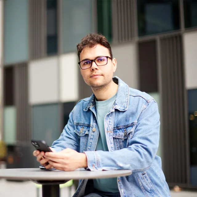 Young professional using a smartphone at an outdoor office space.