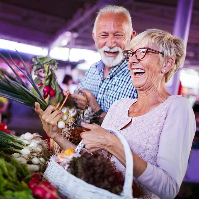 Image of elderly couple enjoying doing grocery in a market