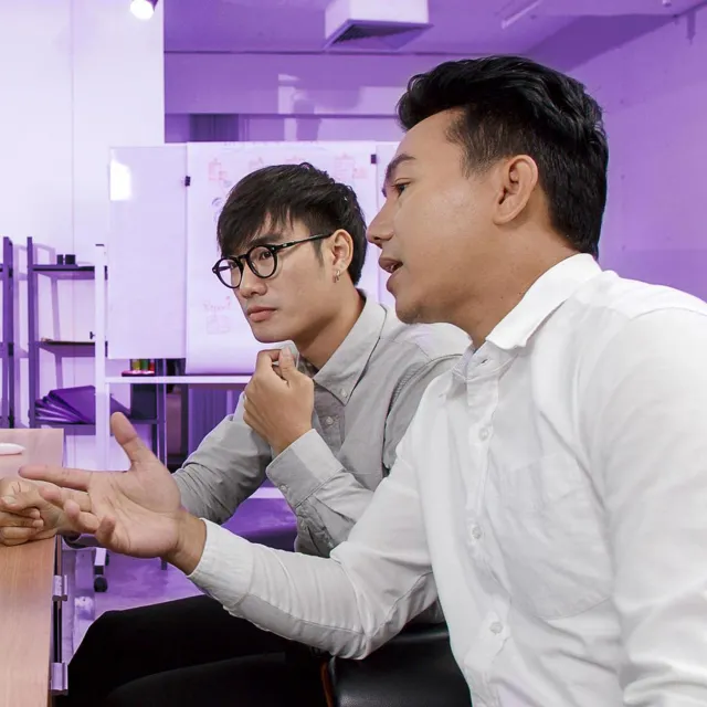 Image of two officemates discussing