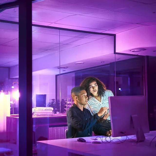 Image of two officemates discussing in a workstation