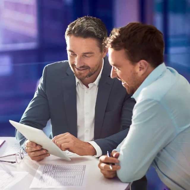 Business professionals reviewing financial documents in a modern office.