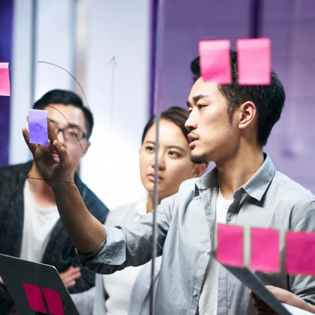 Image of team discussing notes in post-its