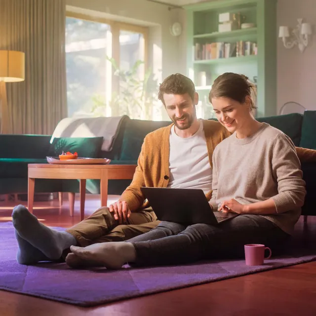 Image of happy couple working on a laptop at home